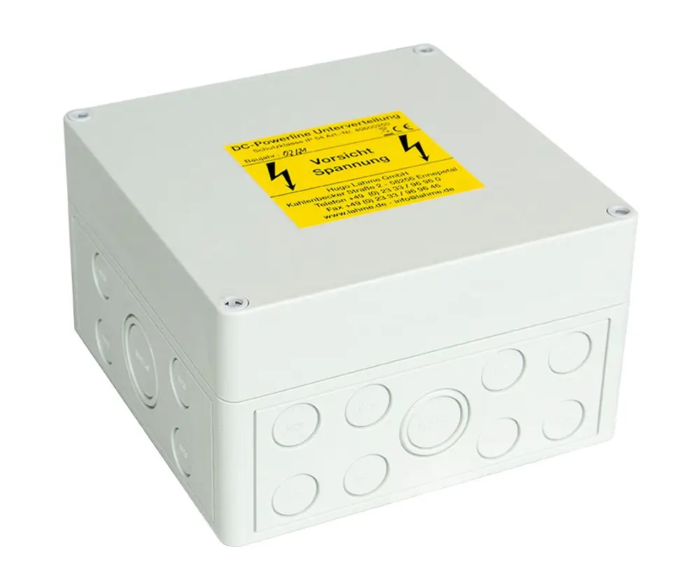 Graue Verteilerdose mit mehreren Taster- und Anschlussfeldern für elektrische Anwendungen, beschriftet mit Warnhinweisen zur Spannung; produziert von Grünbeck.